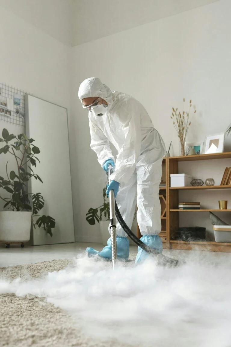 Technician in protective suit deep cleaning a carpet