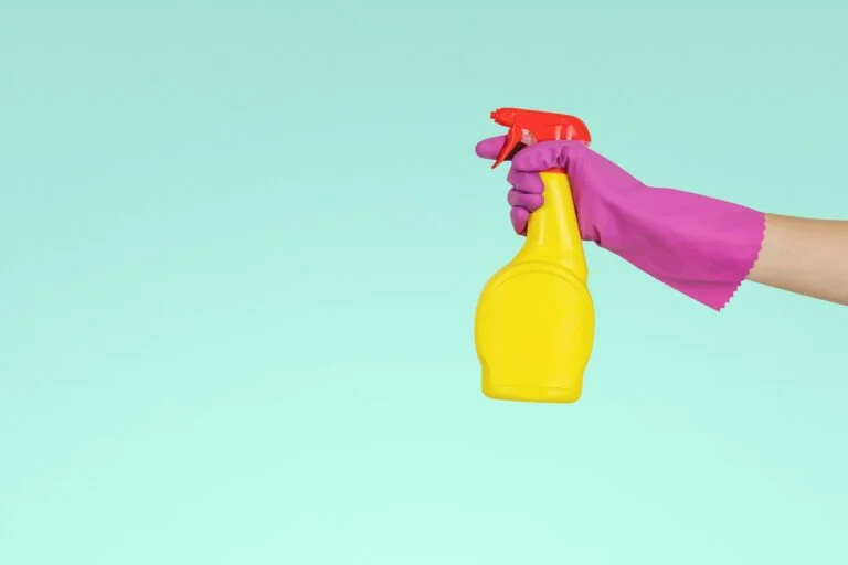 Cleaner holding a yellow spray bottle