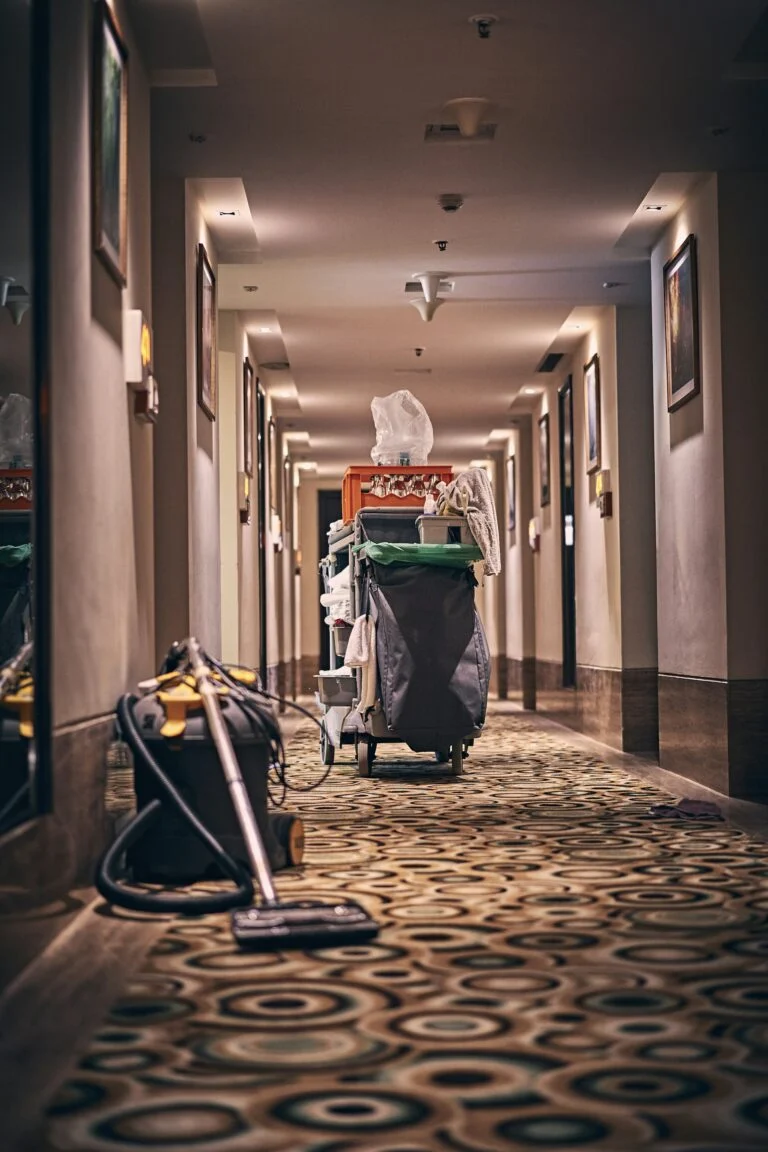 Housekeeping cart and vacuum in a carpeted corridor