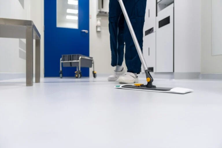 Cleaner mopping a white hallway floor