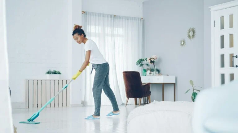 Cleaner mopping a bright modern living room