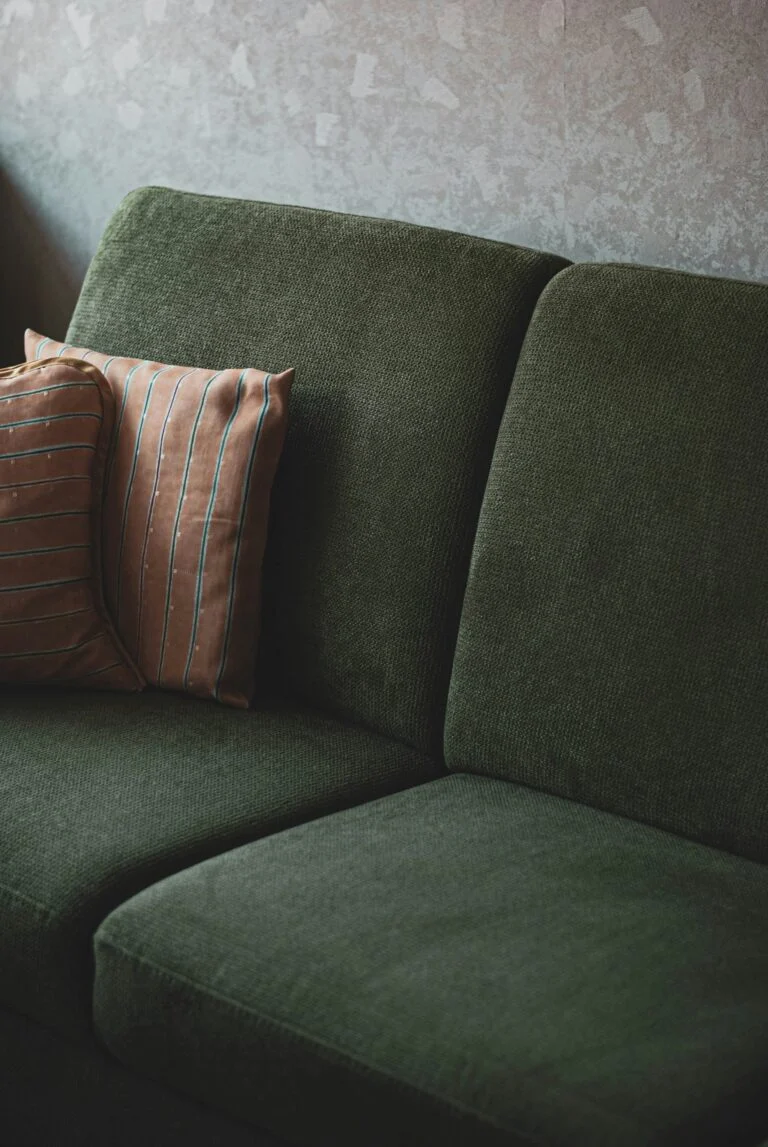 Freshly cleaned green fabric sofa with cushions
